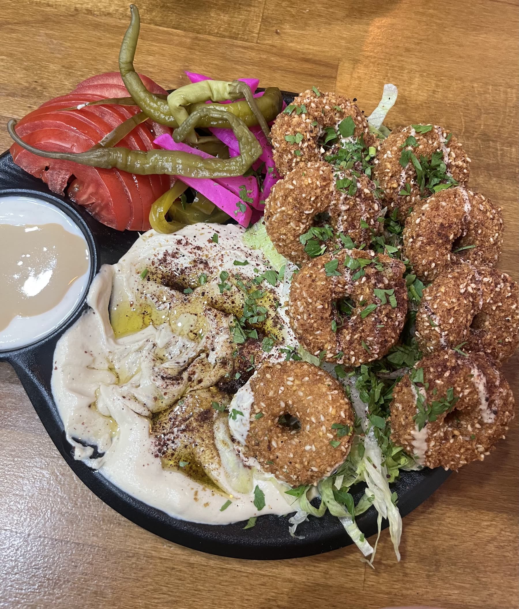 Falafel-Teller mit Hummus, Tahini, Tomaten und eingelegtem Gemüse