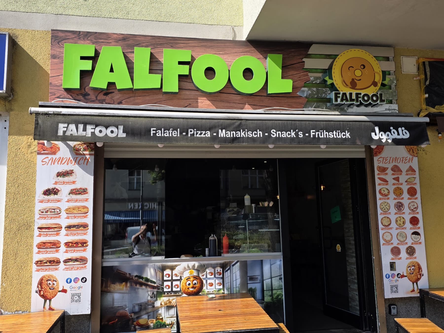 Ladenfront des FALFOOL RESTAURANT auf der Sonnenallee bei Tag, mit grünem Schriftzug und Markise